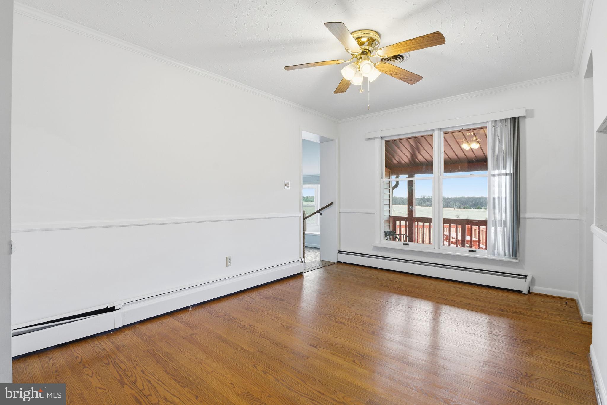 4008 Rock Run Road Havre de Grace, MD 21078 - Photo 10 of 28 an empty room with wooden floor and windows with curtains