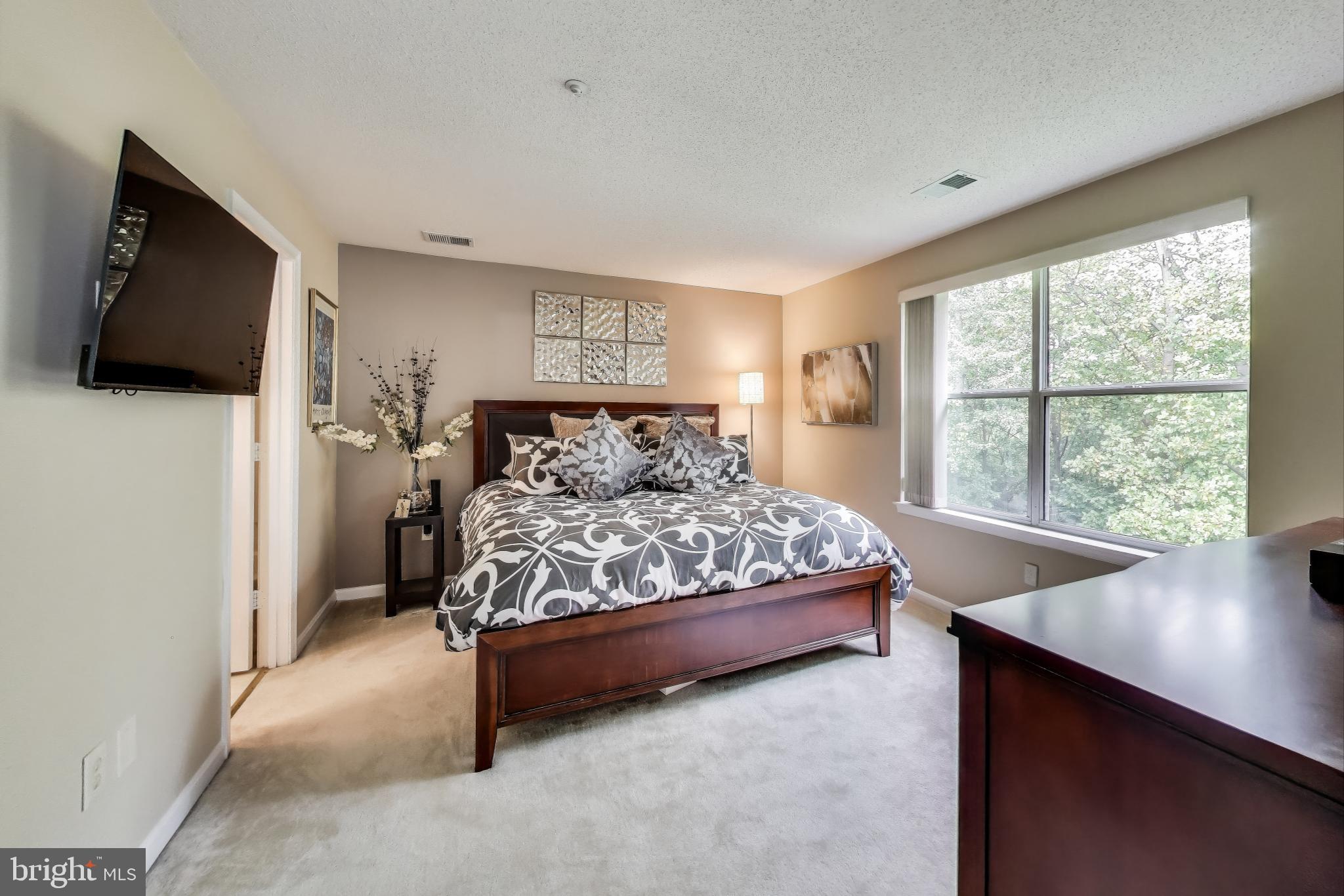 10021 Vanderbilt Circle, Unit 14 Rockville, MD 20850 - Photo 13 of 31 a bedroom with a bed and flat screen tv