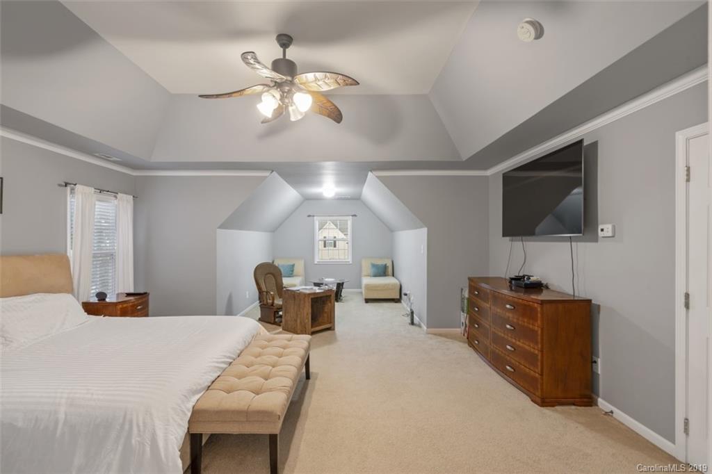 1559 Broderick Street Northwest Concord, NC 28027 - Photo 23 of 29 a bedroom with a bed and a chandelier