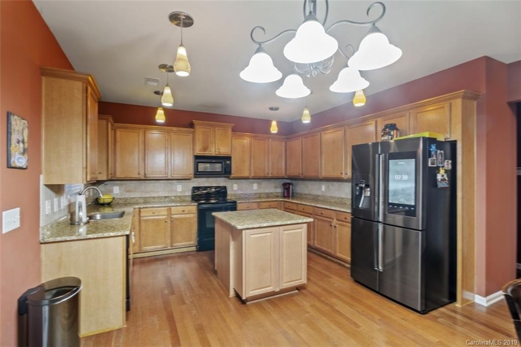 1559 Broderick Street Northwest Concord, NC 28027 - Photo 8 of 29 a kitchen with a chandelier stainless steel appliances and wooden floor