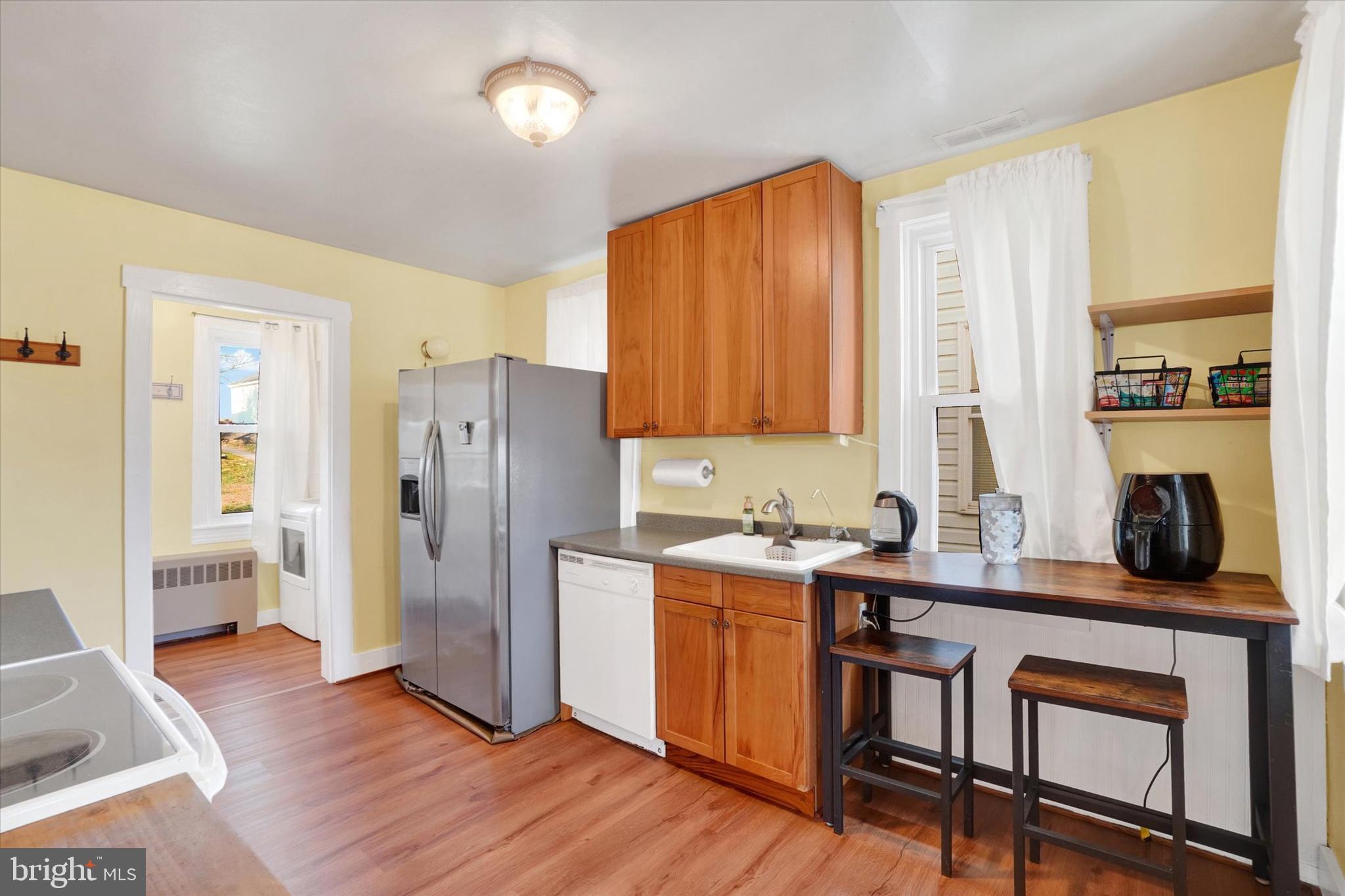 48 High Street Felton, PA 17322 - Photo 11 of 28 a kitchen with stainless steel appliances granite countertop a refrigerator a sink dishwasher a dining table and chairs with wooden floor