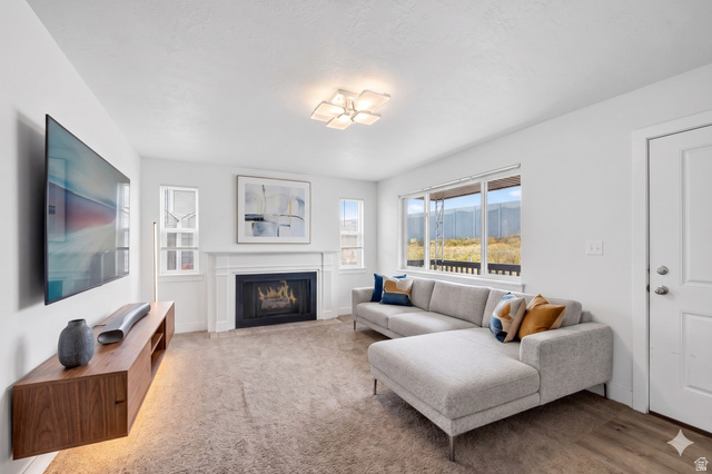 7879 Oak Street Midvale, UT 84047 - Photo 5 of 32 Bright living area featuring a fireplace with a white mantel, large windows, recessed lighting, and wood-finish flooring
