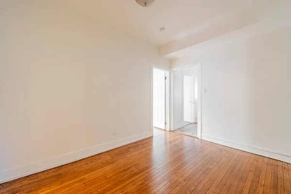a view of an empty room with wooden floor