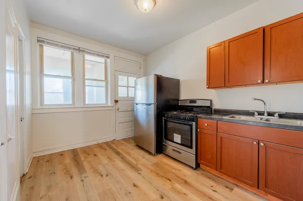 a kitchen with stainless steel appliances granite countertop a stove a sink dishwasher a refrigerator and cabinets with wooden floor