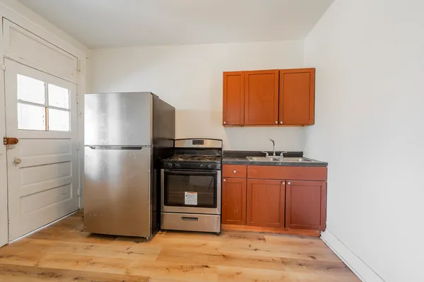 a kitchen with stainless steel appliances granite countertop a refrigerator and a stove top oven