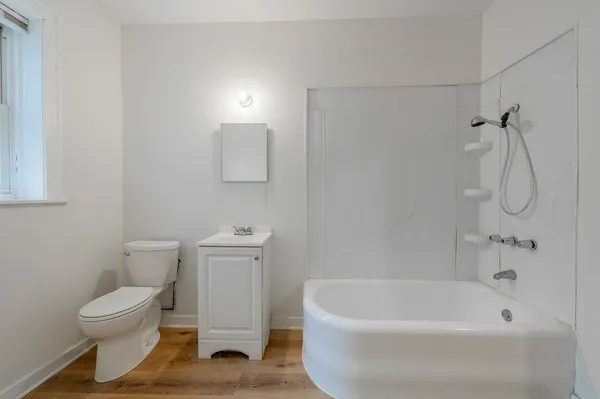 a white toilet sitting next to a bath tub