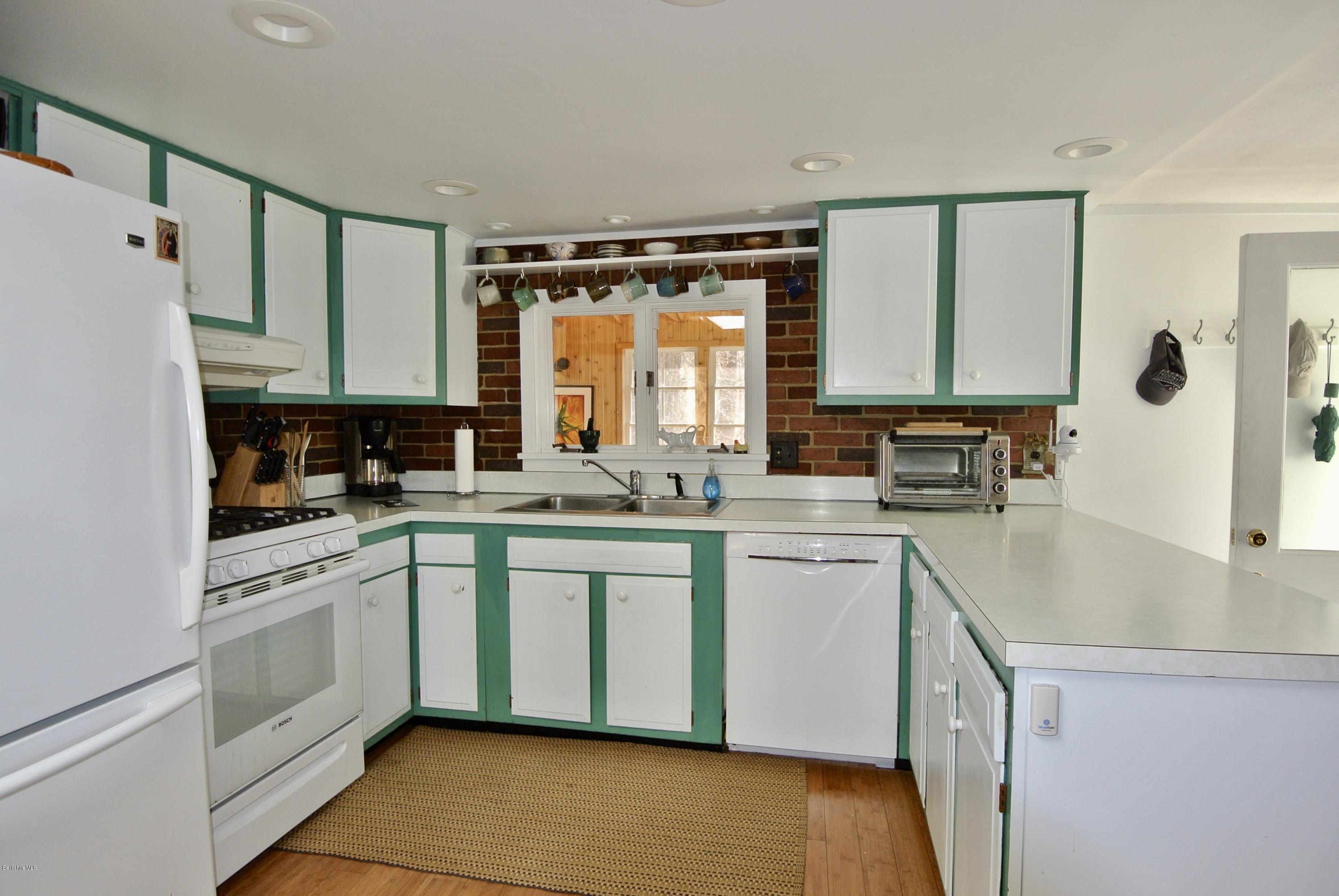 6 Mahkeenac Road Stockbridge, MA 01262 - Photo 11 of 20 a kitchen with white cabinets and white appliances