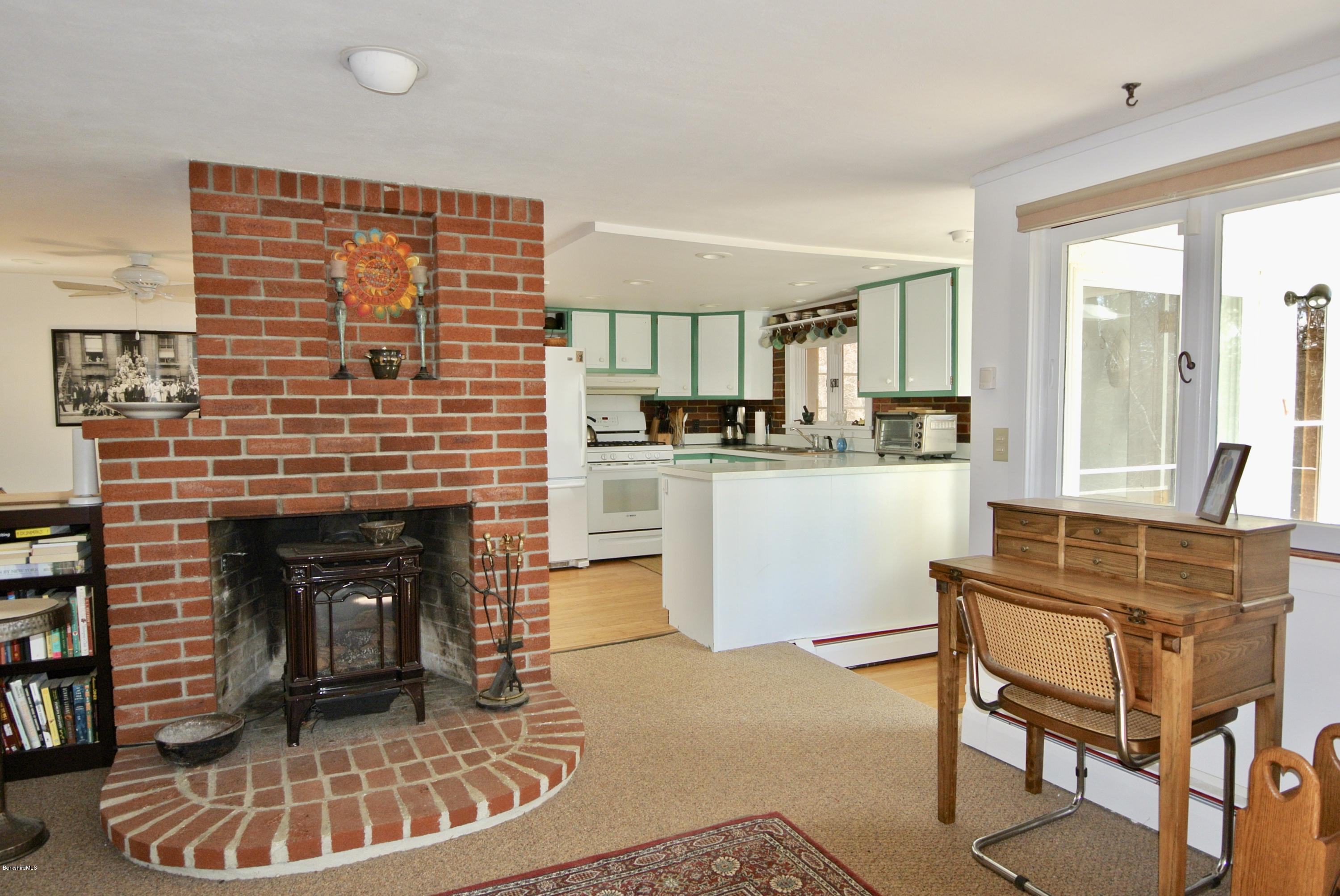 6 Mahkeenac Road Stockbridge, MA 01262 - Photo 7 of 20 a living room with a fireplace and a kitchen view