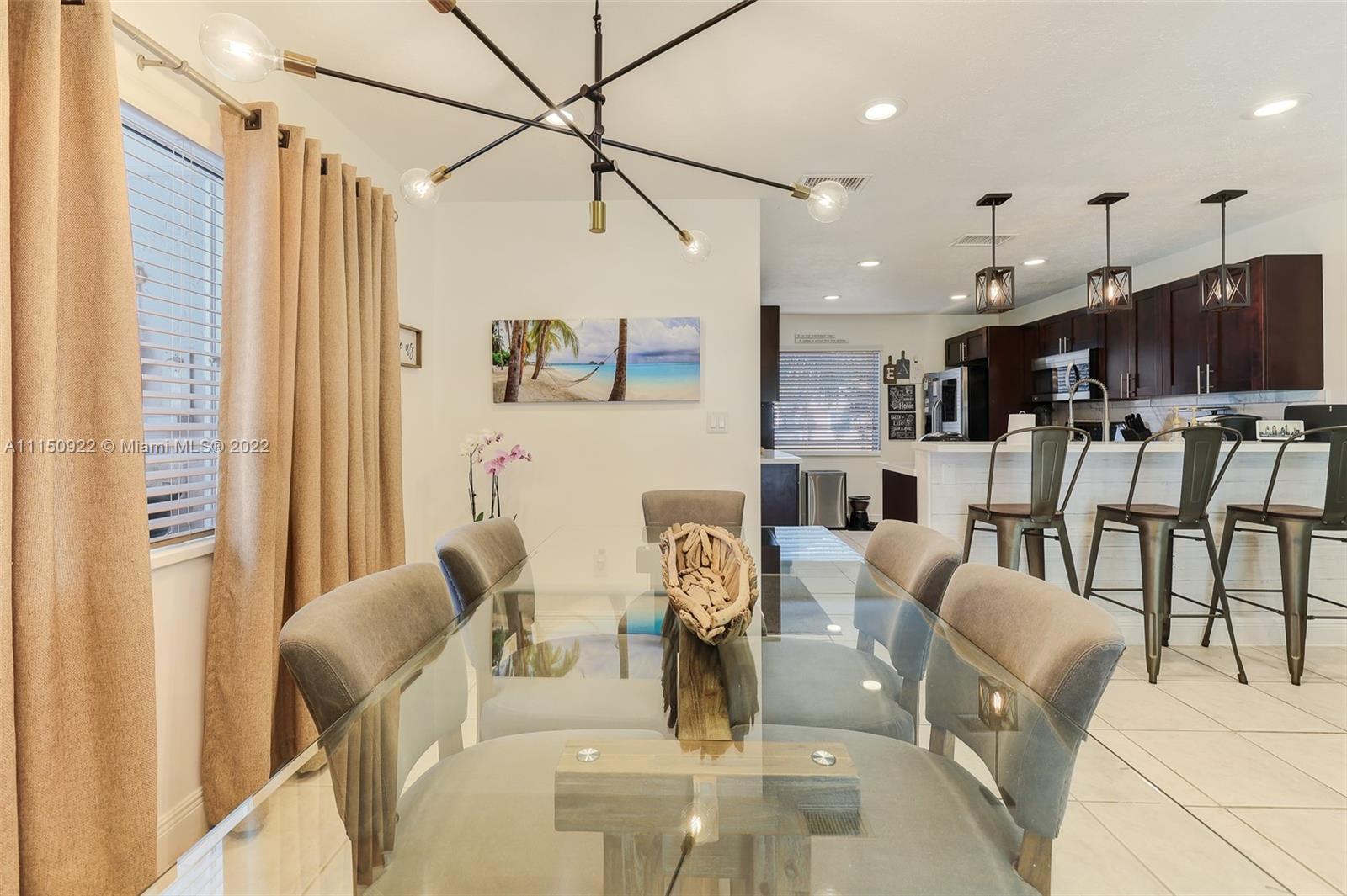 15534 Southwest 153rd Street Miami, FL 33187 - Photo 11 of 44 a living room with lots of furniture and a dining table with wooden floor