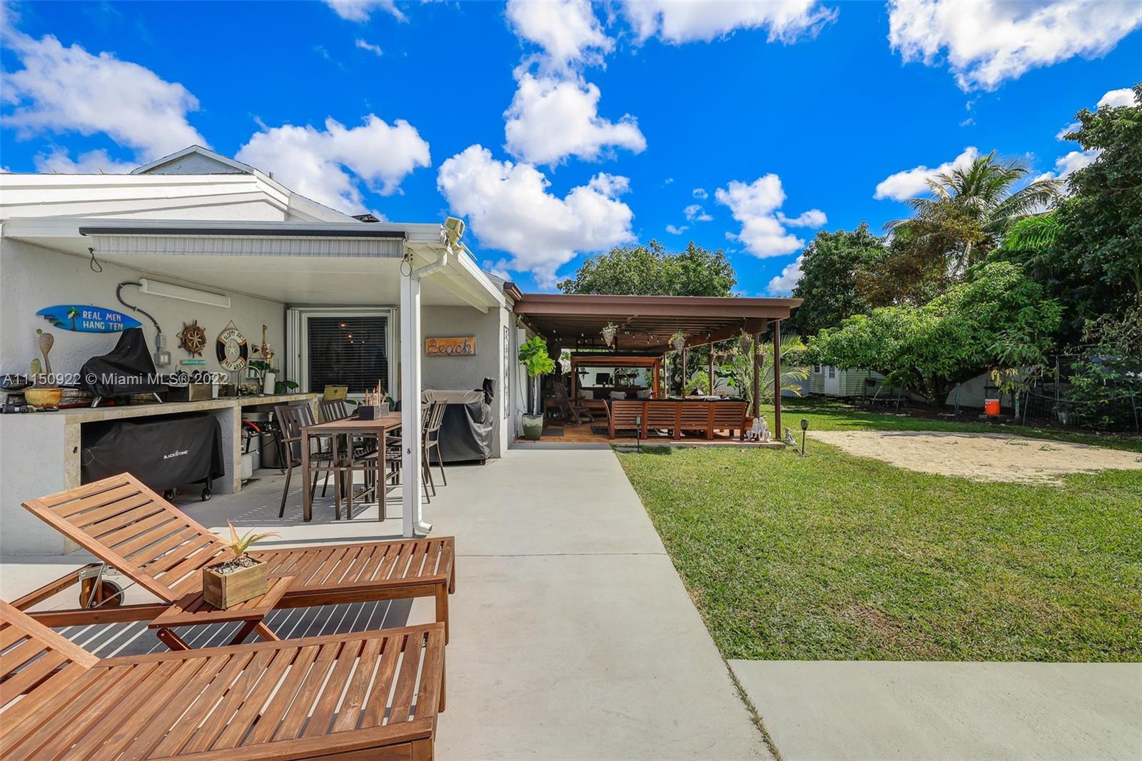 15534 Southwest 153rd Street Miami, FL 33187 - Photo 32 of 44 a view of a patio with table and chairs potted plants and large tree