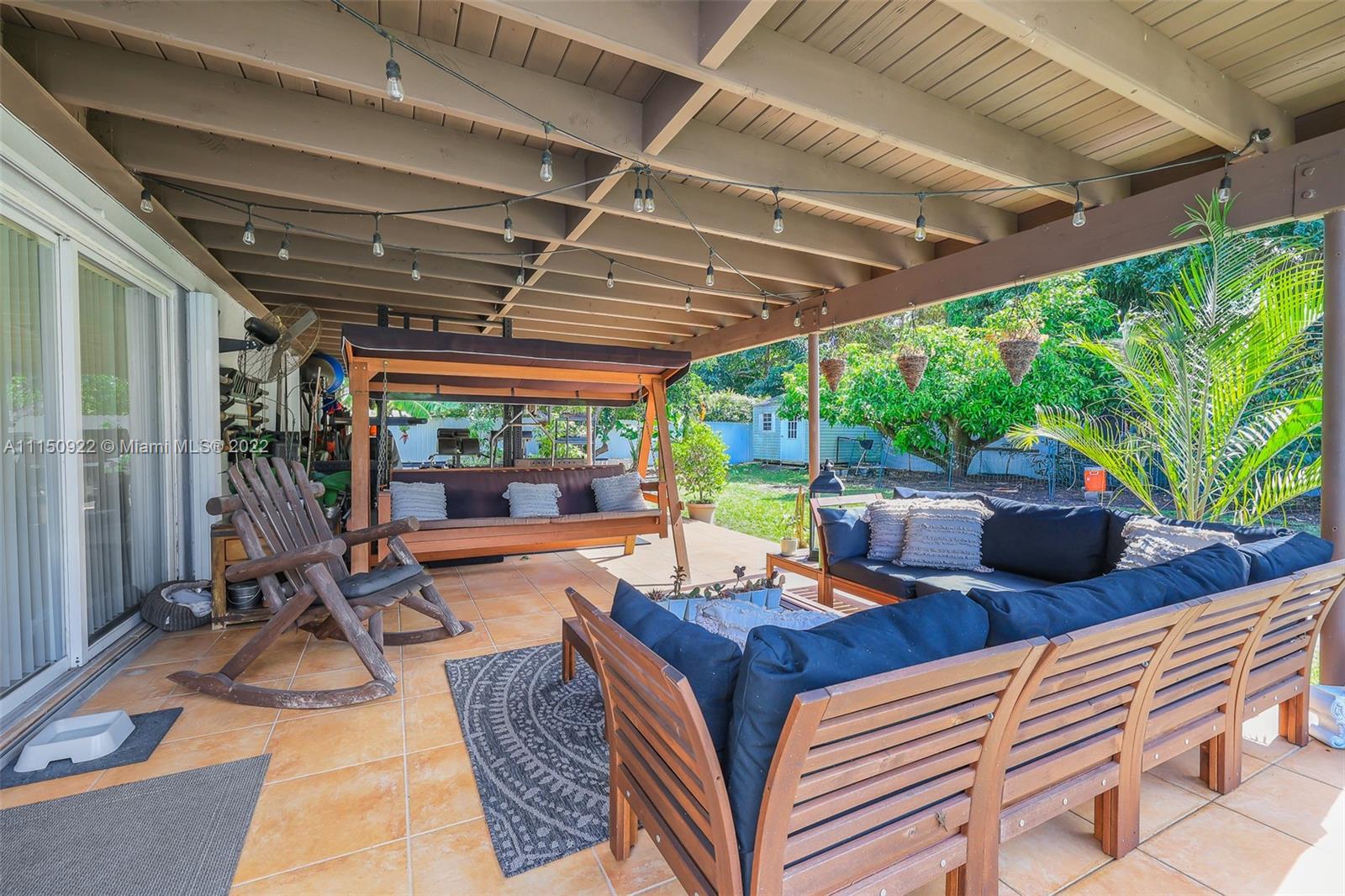 15534 Southwest 153rd Street Miami, FL 33187 - Photo 36 of 44 a view of a patio with table and chairs potted plants with floor to ceiling window and garden