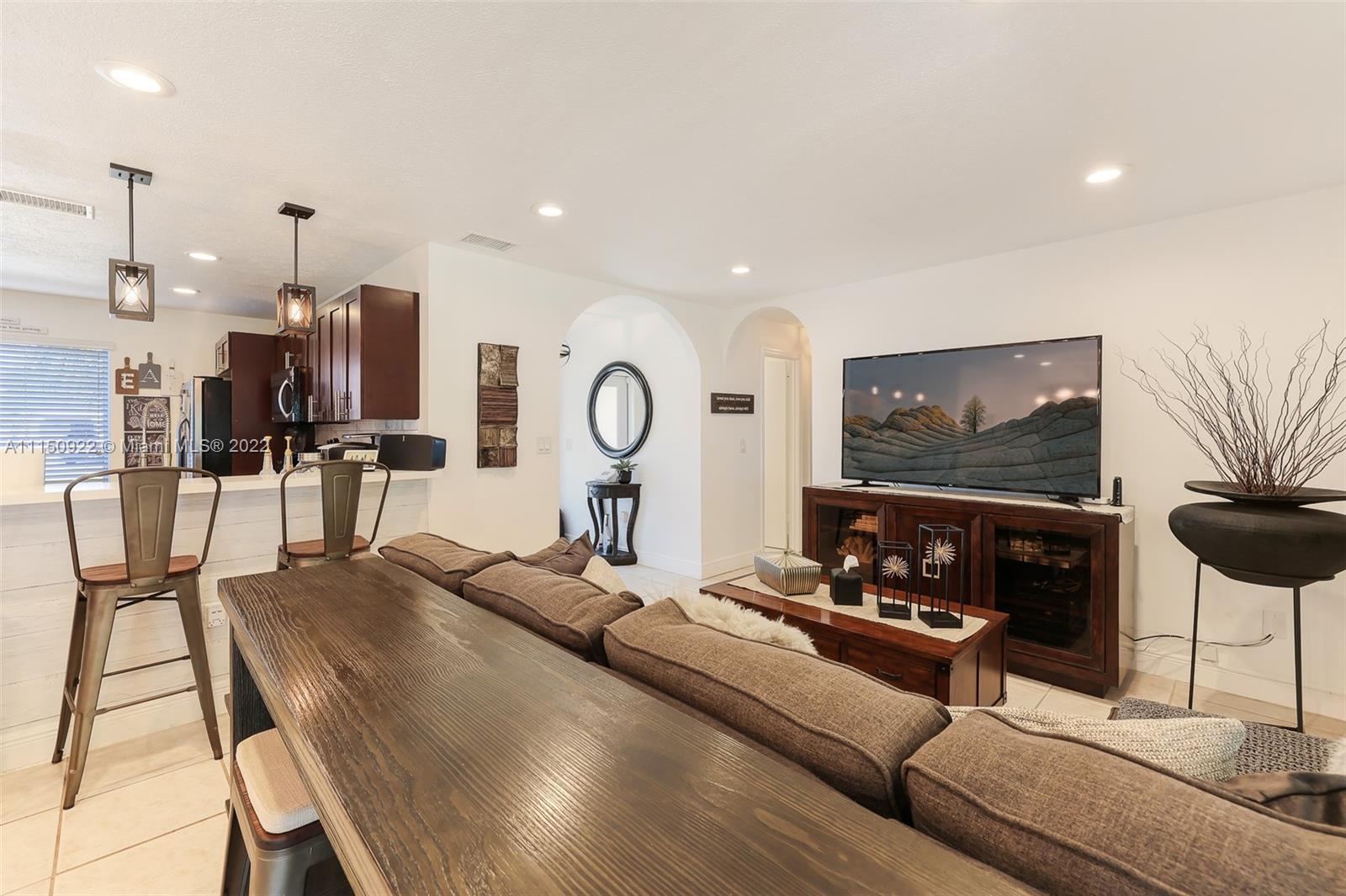 15534 Southwest 153rd Street Miami, FL 33187 - Photo 6 of 44 a living room with furniture kitchen view and a large mirror