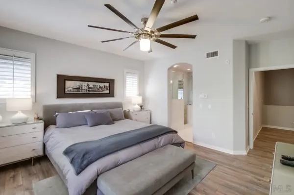 a bedroom with a large bed and a ceiling fan