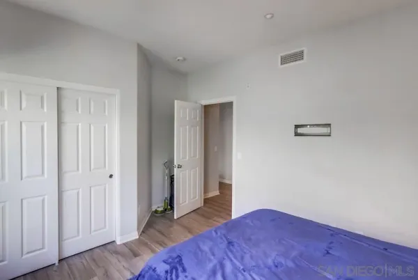 a bedroom with bed and hardwood