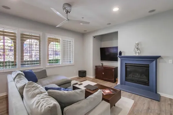 a living room with furniture a flat screen tv and a fireplace