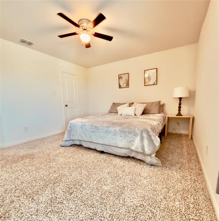196 Cattlemans Crk Road West Newark, TX 76071 - Photo 14 of 24 Carpeted bedroom featuring a ceiling fan with integrated lighting, a solid panel interior door, and light-toned wall finishes