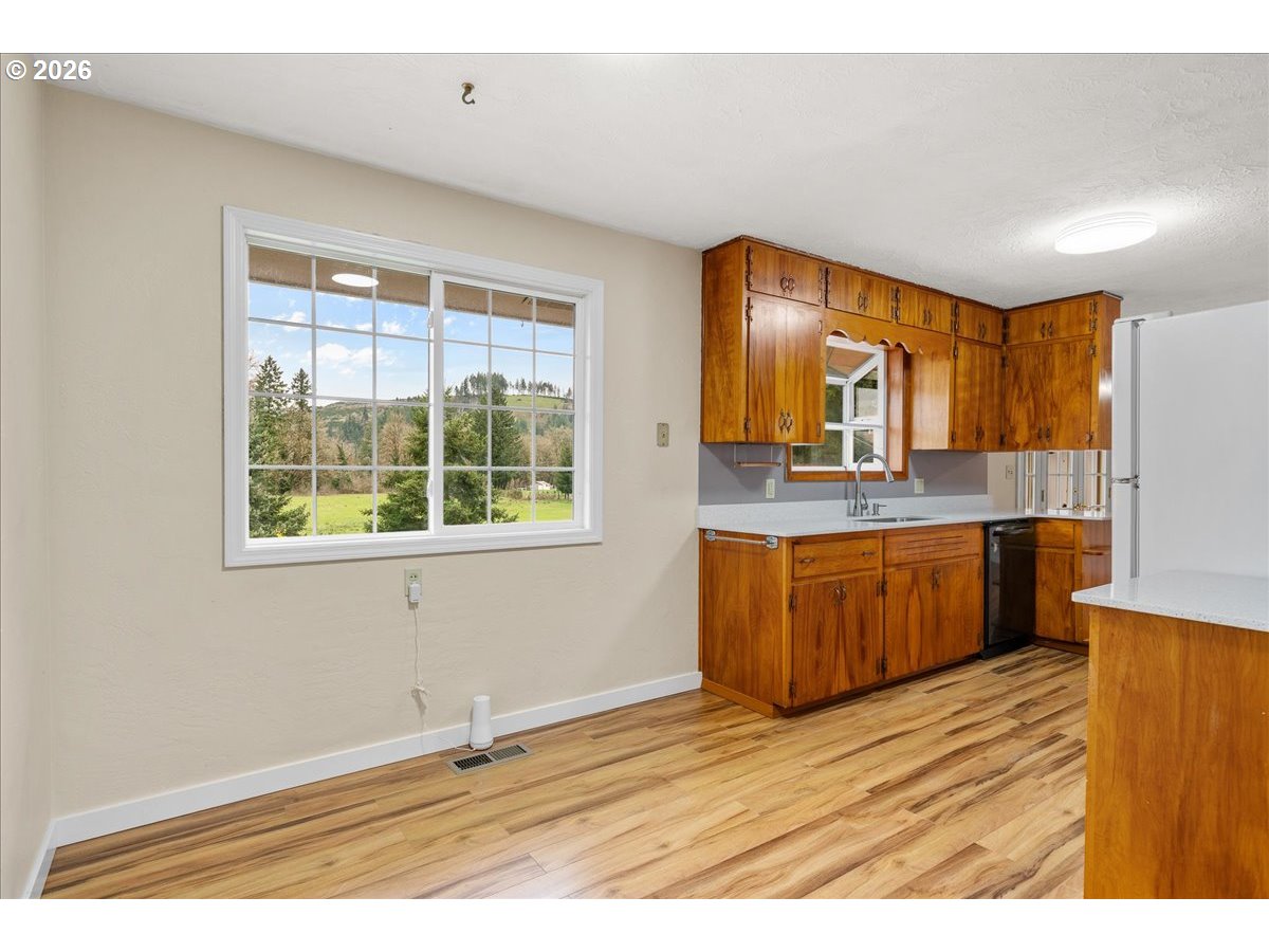 1611 Main Street Lyons, OR 97358 - Photo 12 of 48 a kitchen with stainless steel appliances granite countertop a sink cabinets and wooden floor
