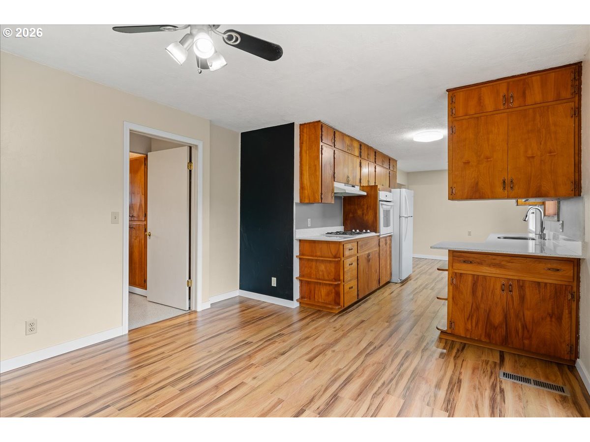 1611 Main Street Lyons, OR 97358 - Photo 21 of 48 a open kitchen with stainless steel appliances granite countertop a refrigerator a sink dishwasher a oven with wooden cabinets and wooden floor