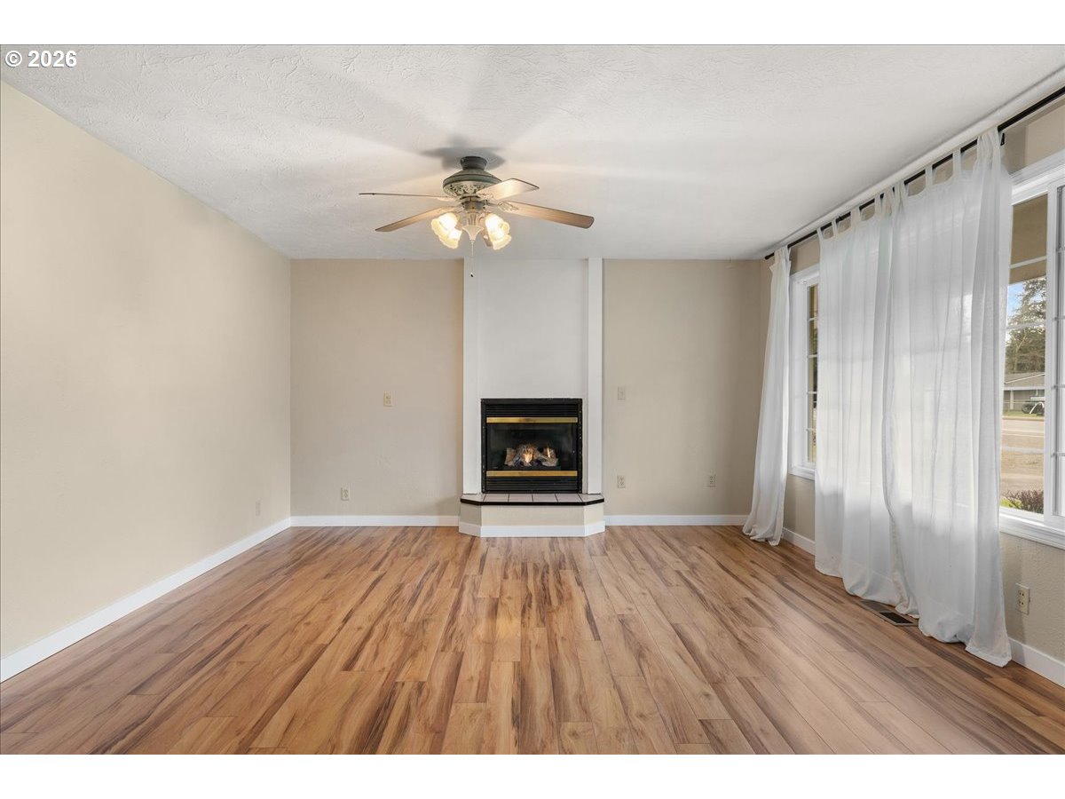 1611 Main Street Lyons, OR 97358 - Photo 8 of 48 a view of an empty room with a fireplace and a window
