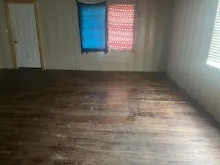 a view of a room with wooden floor and a window