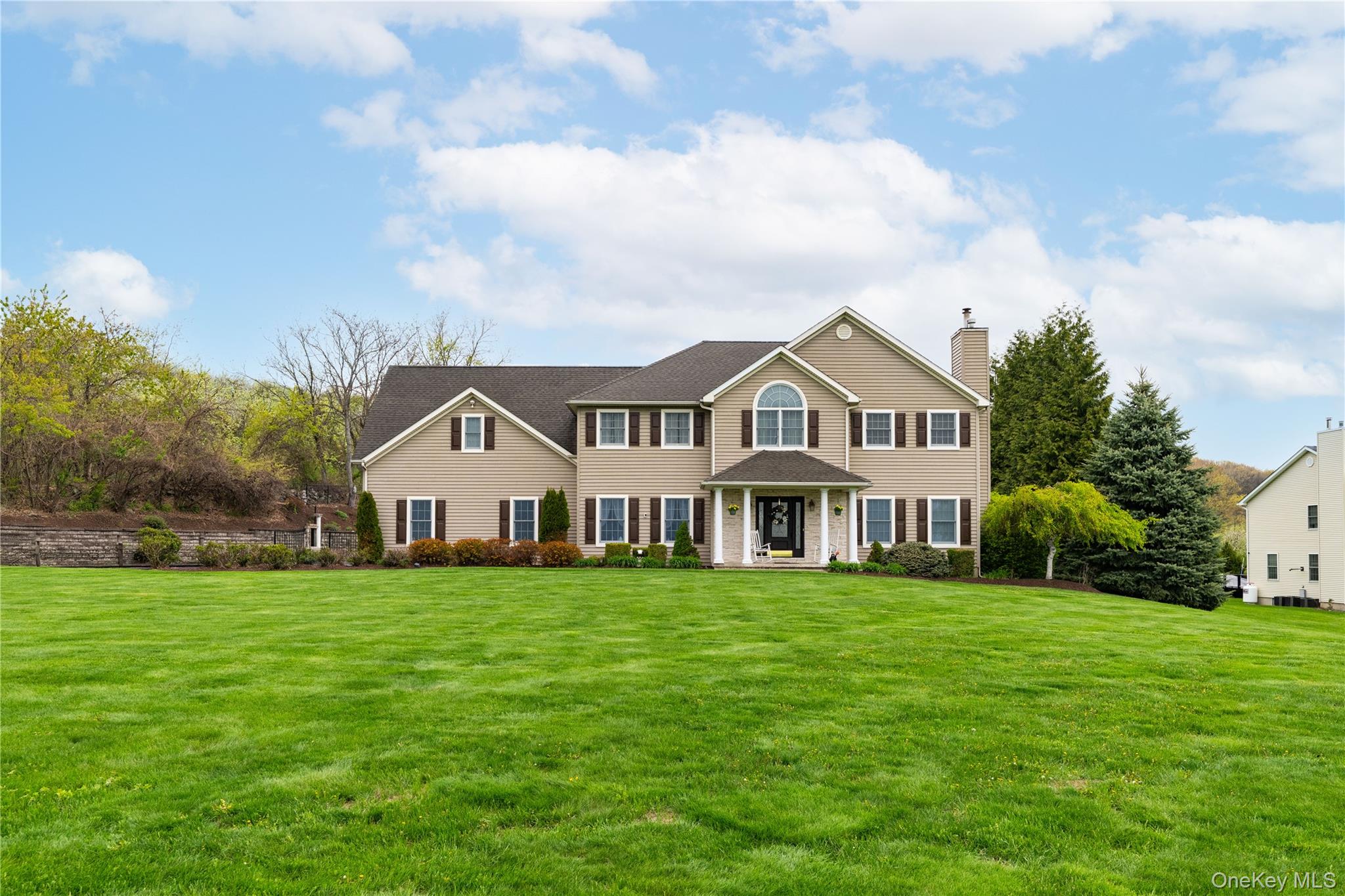 Traditional style residence featuring a broad front lawn