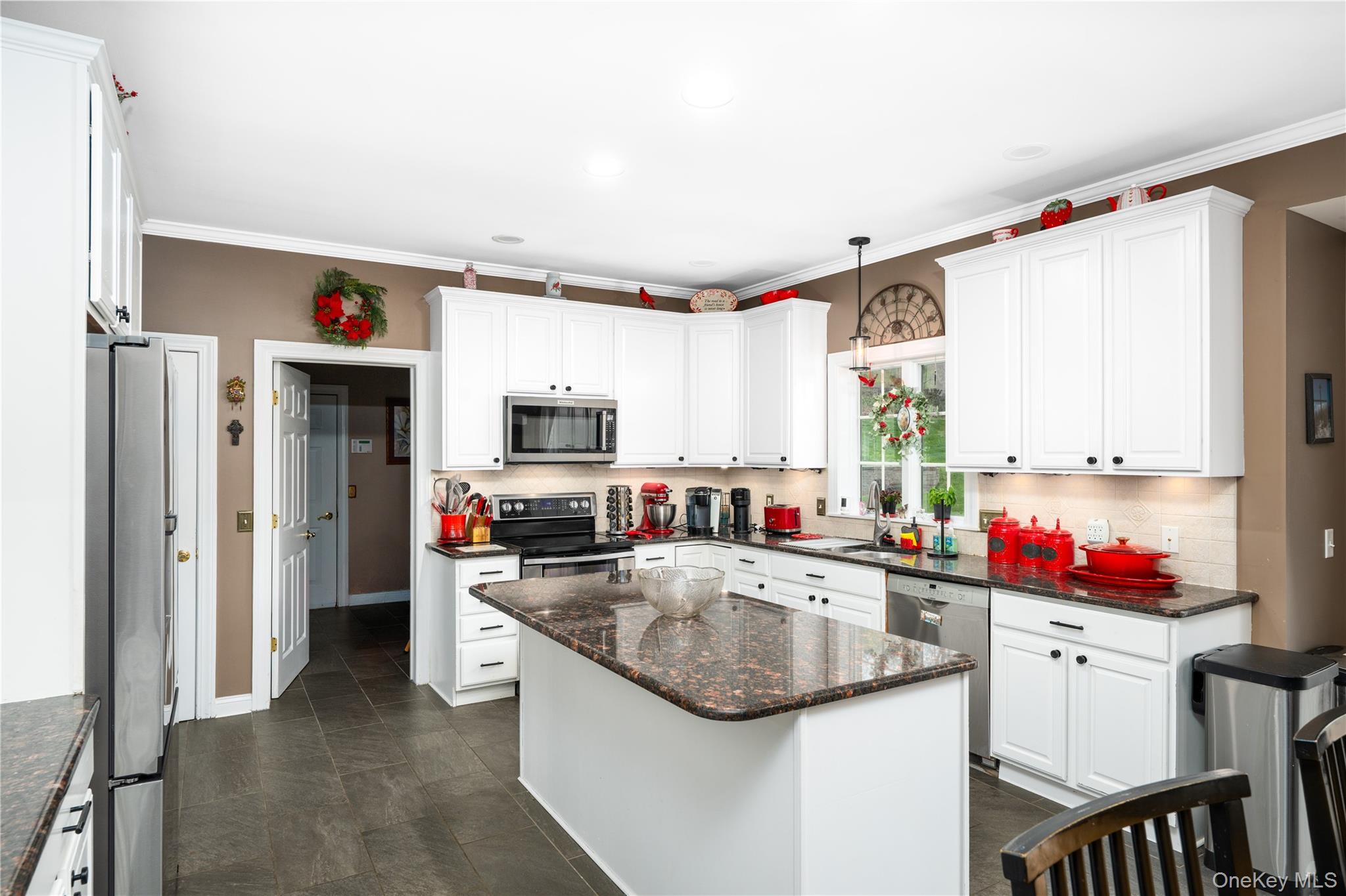 60 Idlewild Road Marlboro, NY 12542 - Photo 12 of 37 Kitchen featuring white cabinetry, dark granite countertops, stainless steel appliances, a central island, and dark tile flooring