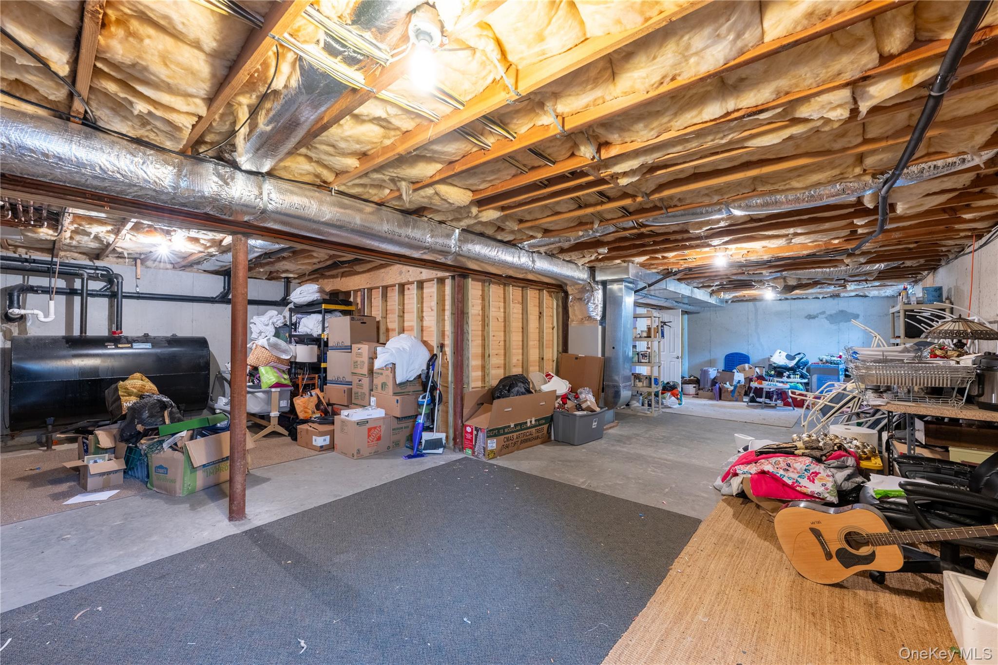 60 Idlewild Road Marlboro, NY 12542 - Photo 34 of 37 Unfinished lower level with exposed ceiling joists and insulation, concrete flooring, and a visible heating oil tank
