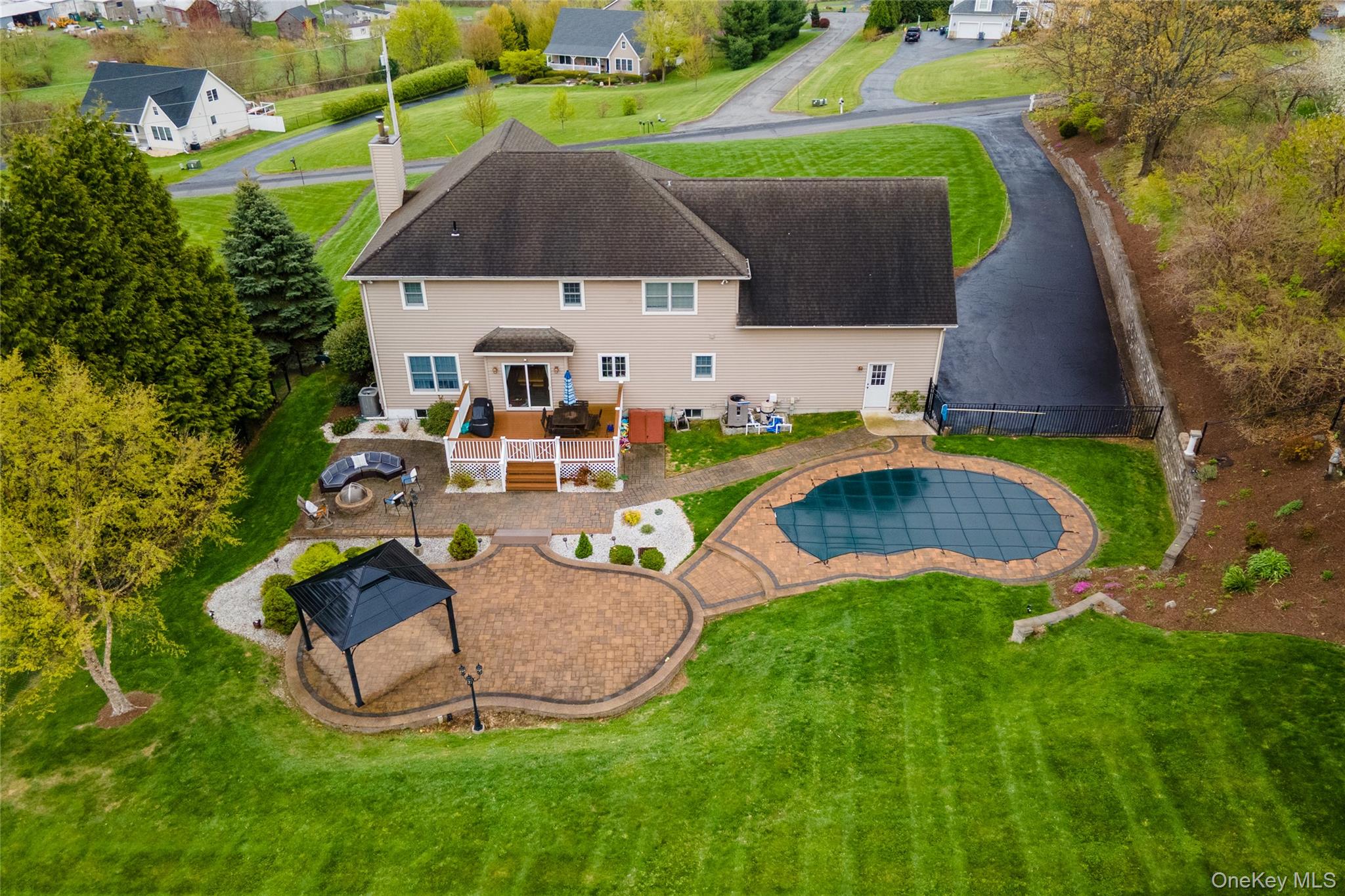60 Idlewild Road Marlboro, NY 12542 - Photo 37 of 37 Rear exterior featuring a multi-level composite deck, an expansive paver patio with a gazebo, and a freeform swimming pool with a hard cover