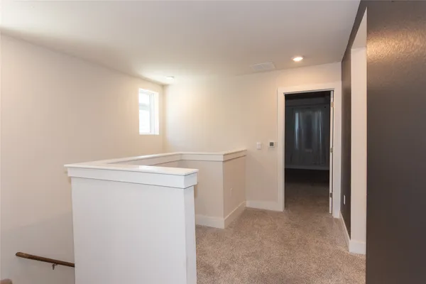 a view of an empty room with closet and a window