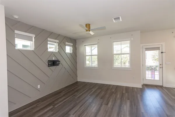 a large kitchen with stainless steel appliances kitchen island wooden floors and white walls