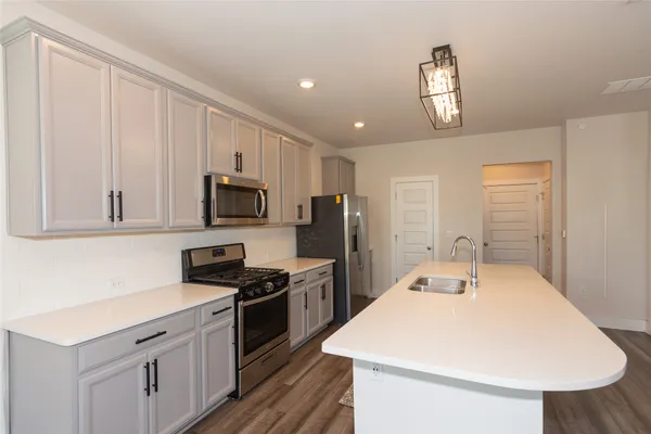 a kitchen with stainless steel appliances a microwave a stove and refrigerator