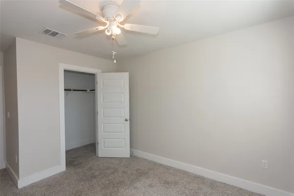 an empty room with a window and a fan