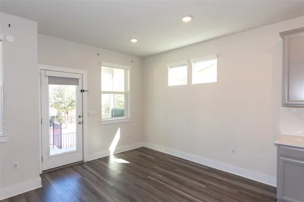 a view of a kitchen with wooden floor and a window