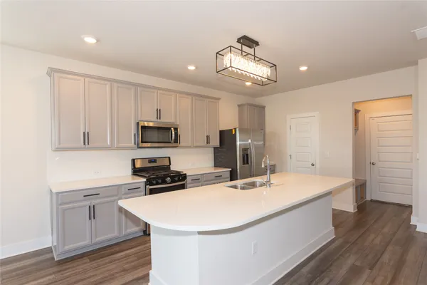 a kitchen with a sink stainless steel appliances and white cabinets
