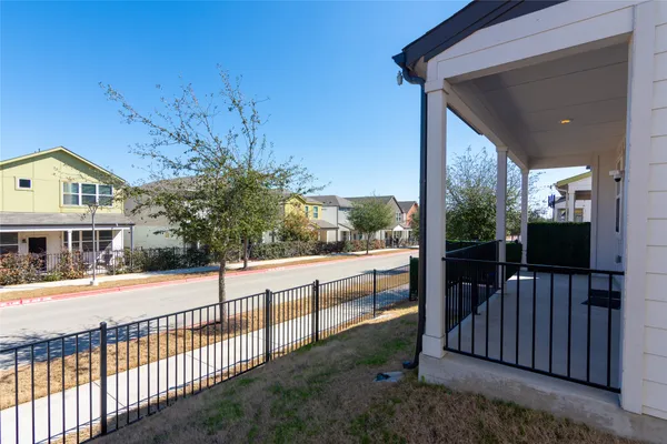 a view of a house with a small yard and wooden fence