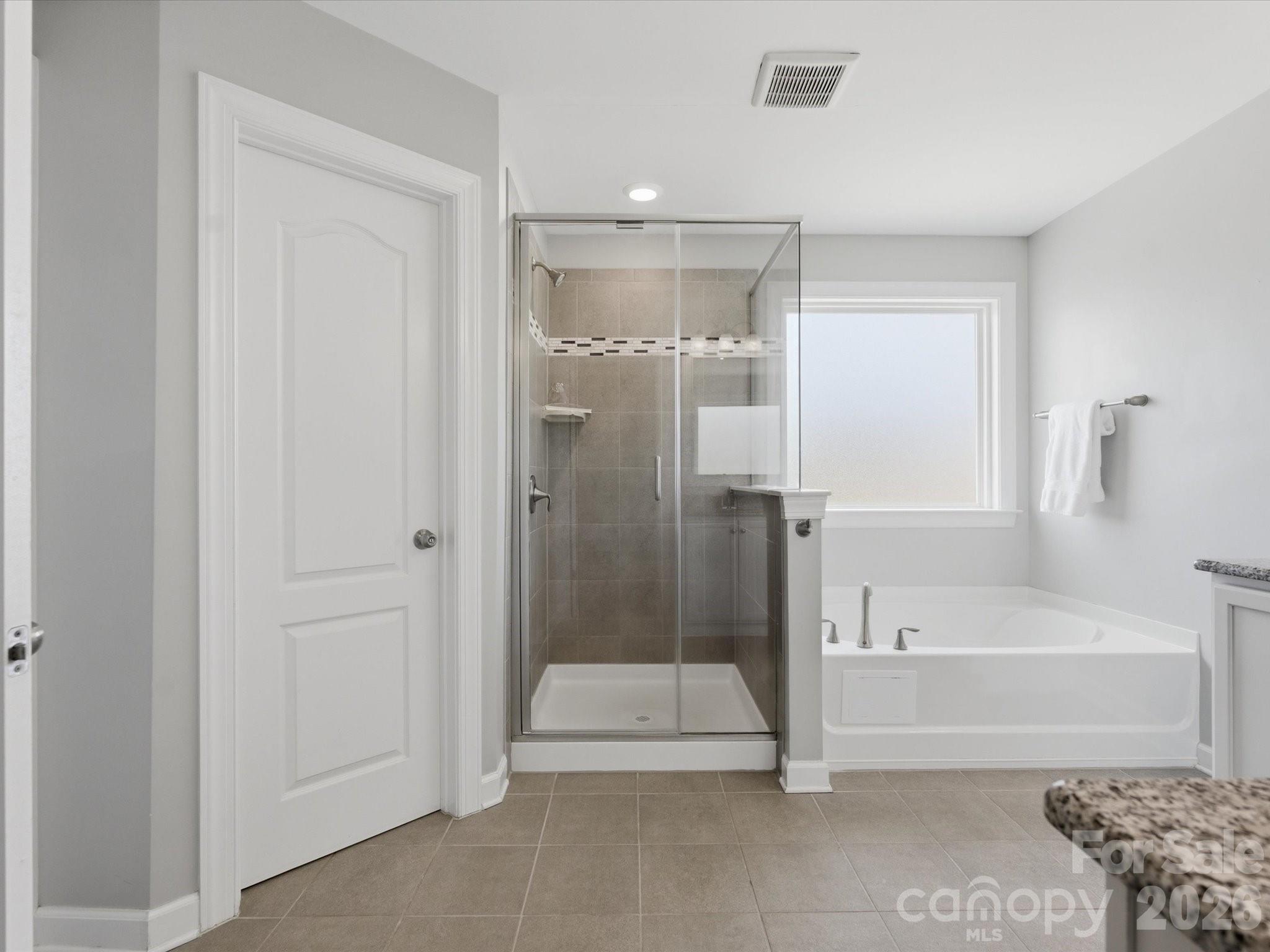 932 Twin Valley Way Fort Mill, SC 29715 - Photo 23 of 48 a bathroom with a tub shower and checkered floor