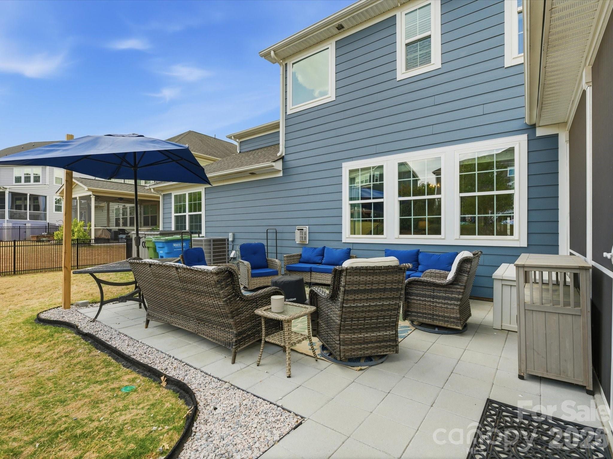 932 Twin Valley Way Fort Mill, SC 29715 - Photo 34 of 48 a view of a patio with couches table and chairs under an umbrella