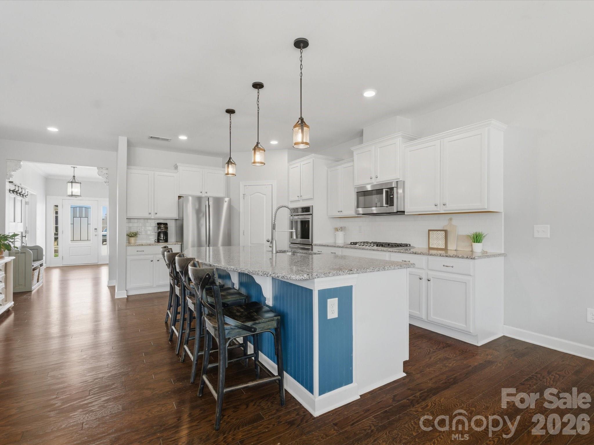 932 Twin Valley Way Fort Mill, SC 29715 - Photo 6 of 48 a large kitchen with kitchen island a dining table chairs and white cabinets