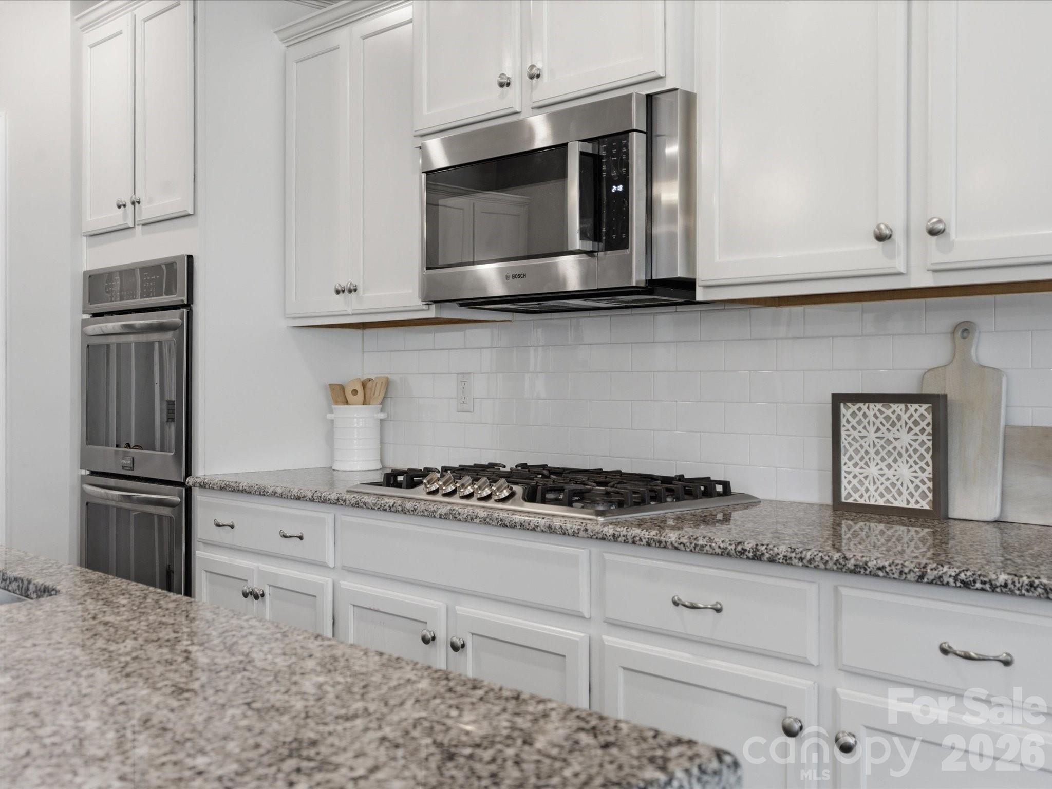 932 Twin Valley Way Fort Mill, SC 29715 - Photo 9 of 48 a kitchen with granite countertop white cabinets and stainless steel appliances