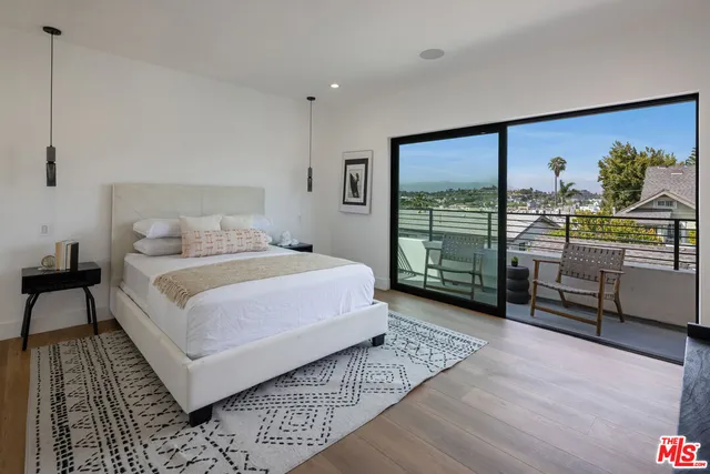 a bedroom with a bed table and a window
