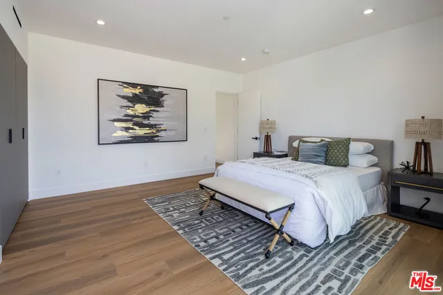 a bedroom with a bed and wooden floor