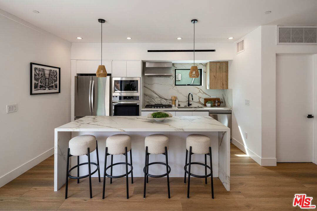 2003 Bellevue Avenue Los Angeles, CA 90026 - Photo 7 of 30 a kitchen with stainless steel appliances kitchen island a refrigerator and microwave