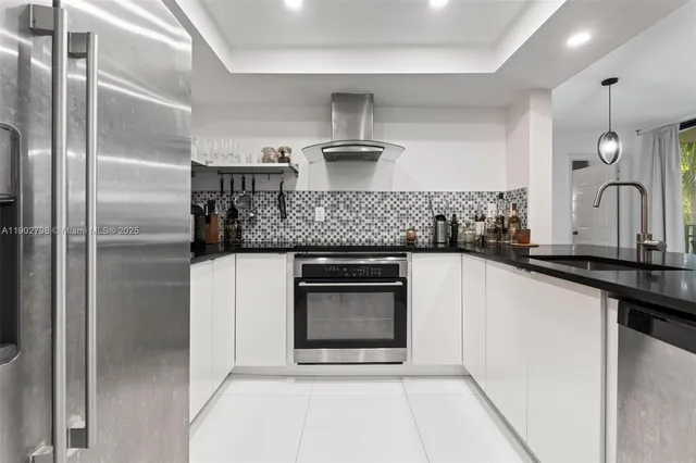 a kitchen with stainless steel appliances granite countertop a stove a sink and a refrigerator