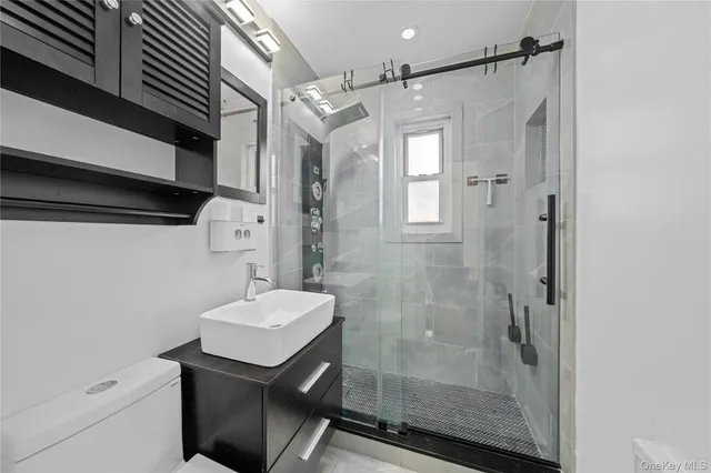 a bathroom with a sink mirror and a shower