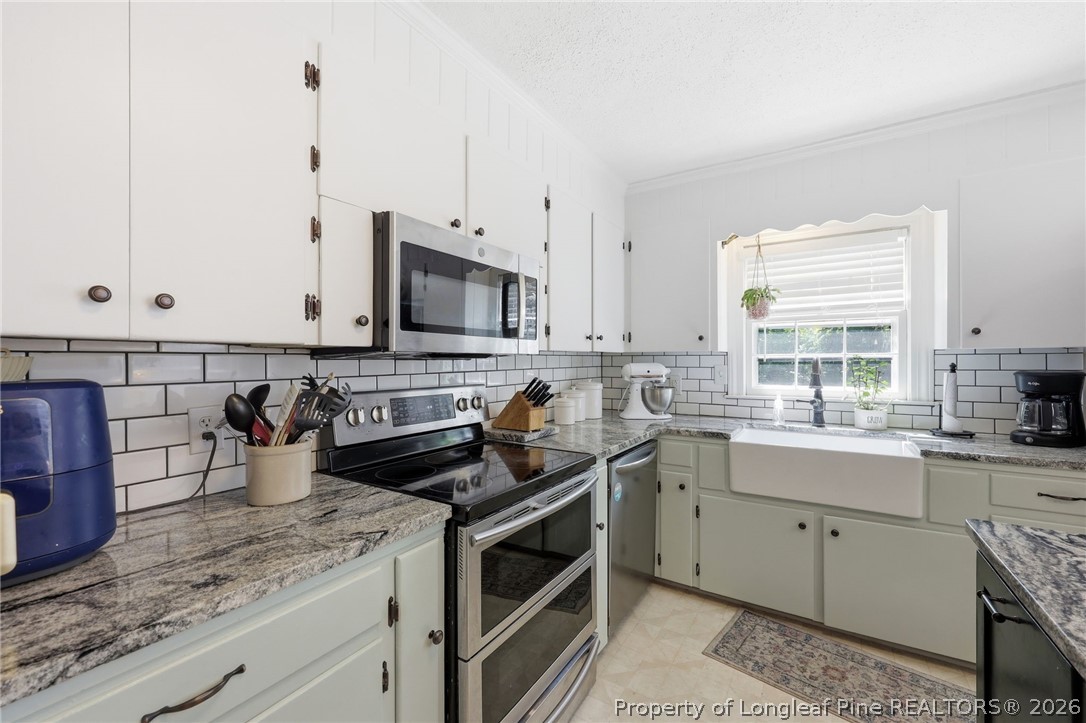 1322 Carolina Drive Rockingham, NC 28379 - Photo 15 of 28 a kitchen with stainless steel appliances granite countertop a sink stove and cabinets