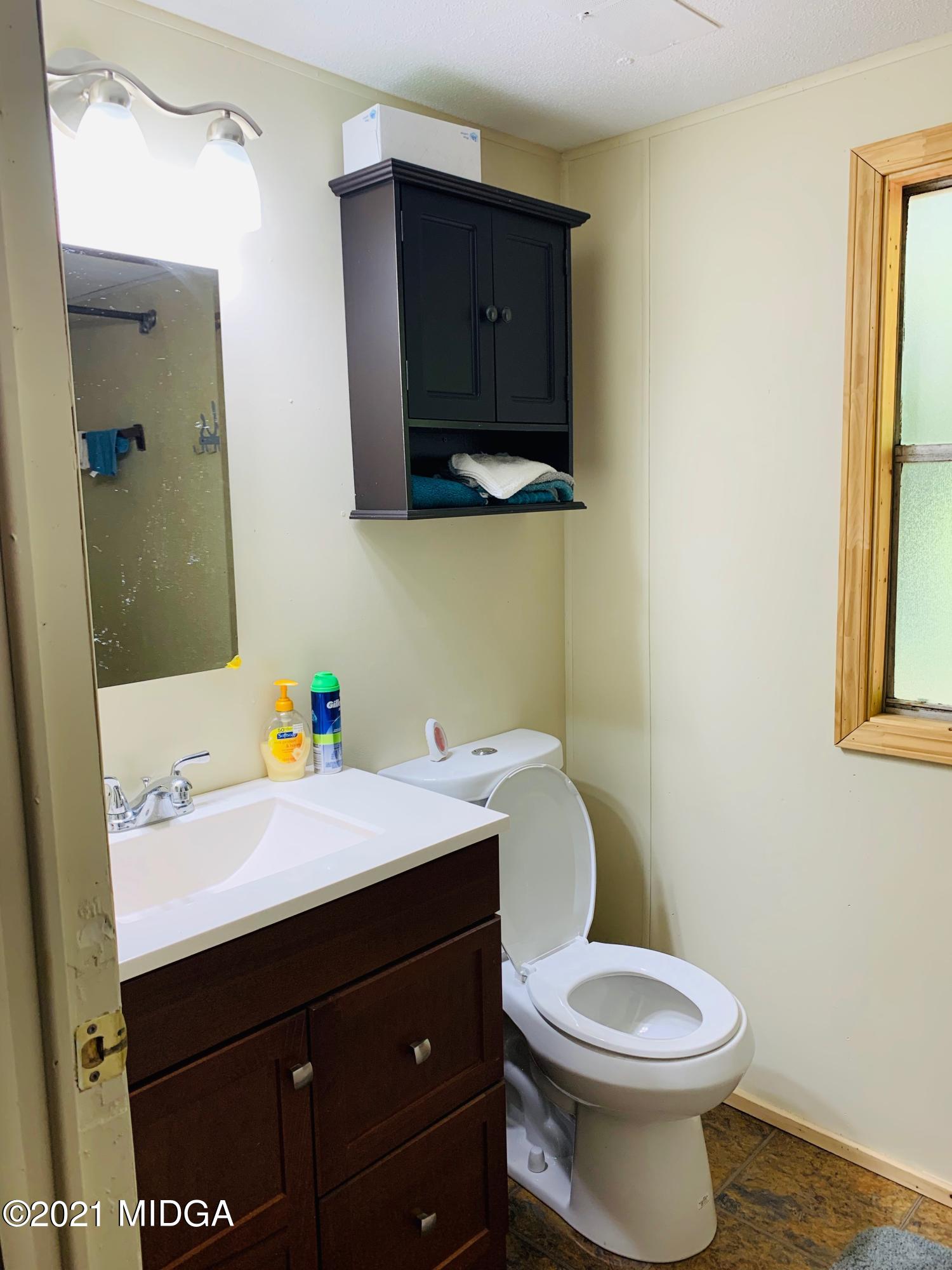777 Watson Road Forsyth, GA 31029 - Photo 15 of 16 a bathroom with a toilet sink and mirror