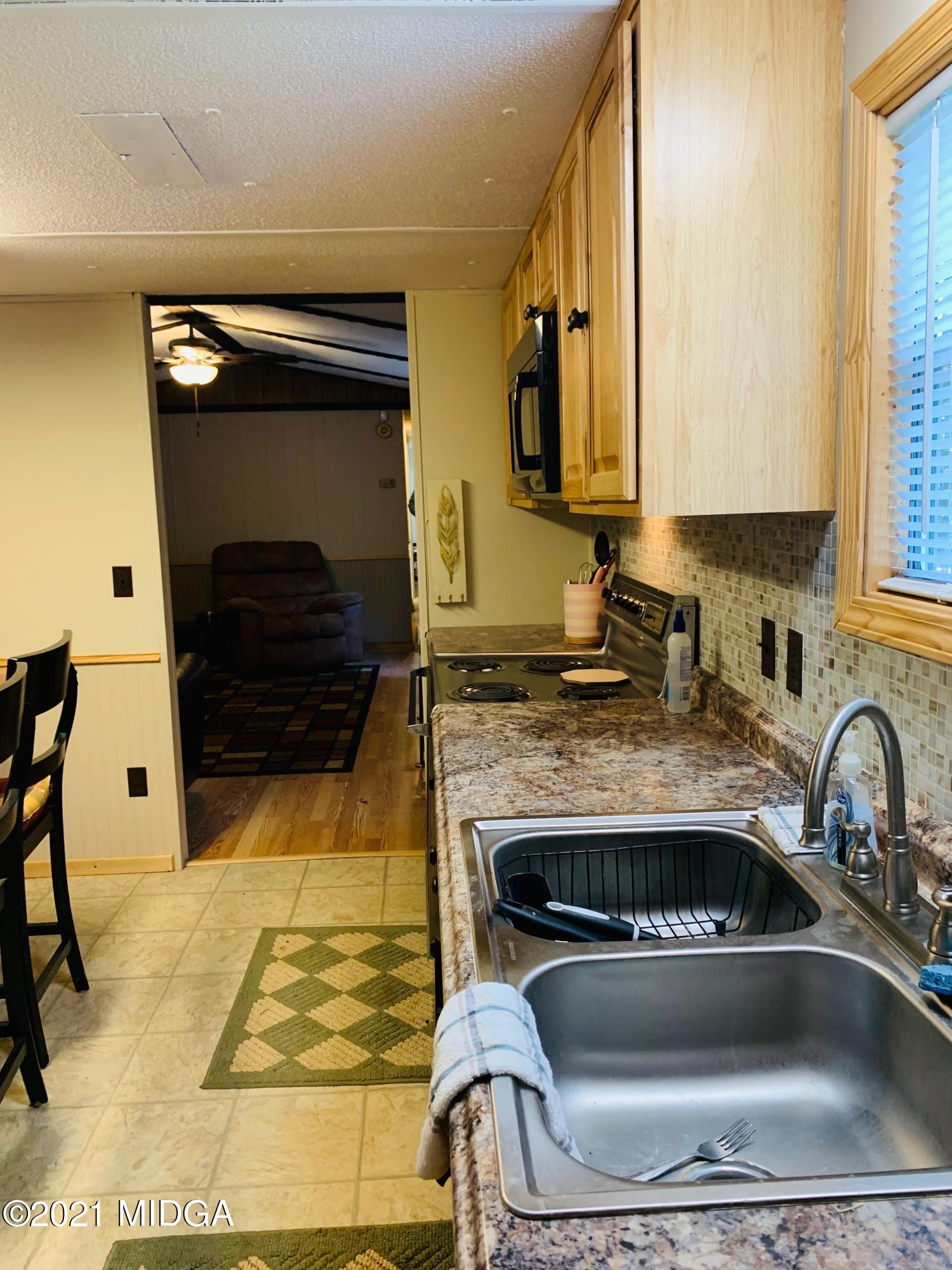 777 Watson Road Forsyth, GA 31029 - Photo 9 of 16 a kitchen with a stove a sink and a microwave