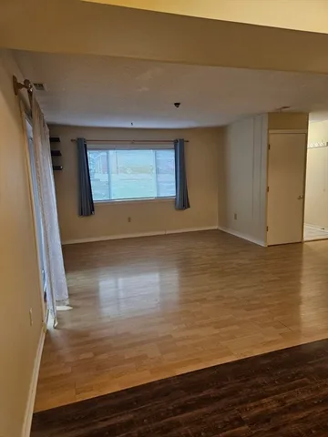 a view of room with window and wooden floor