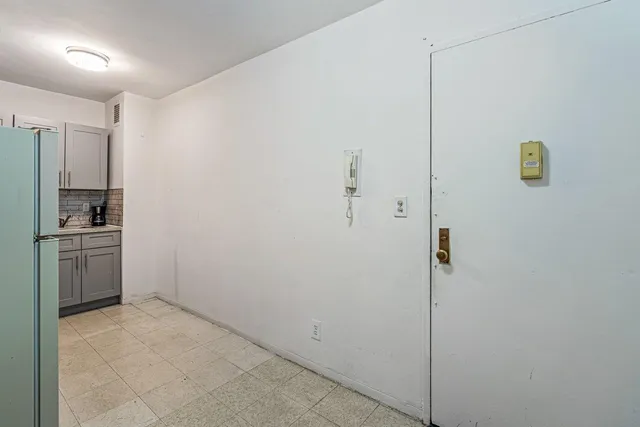 a view of a kitchen with a sink a refrigerator and cabinets
