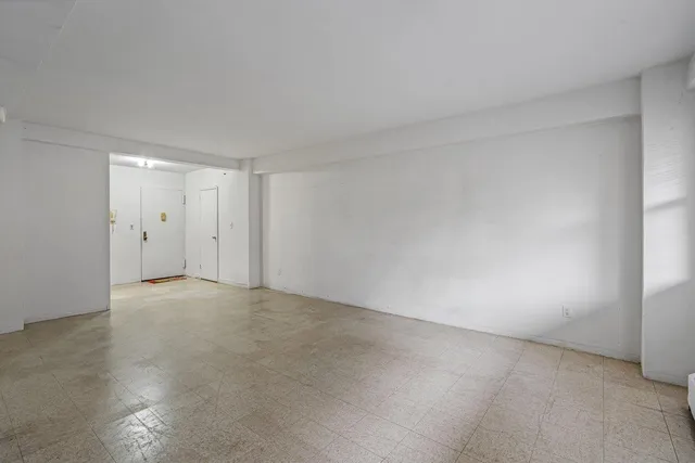 a view of an empty room and chandelier fan